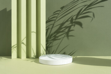 White round podium on an abstract green background with a shadow of palm leaves. A scene with a...