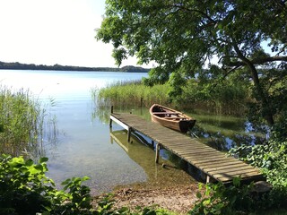 Beautiful peaceful summer lake photo of bathing bridge and boat in the water