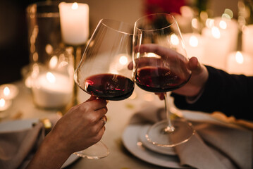 Cheers. Couple in love drinking wine. Romantic date by candlelight at night. Hands man and woman...
