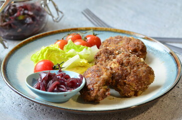 Meatballs with salad and cherry tomatoes on a plate. Selective focus.