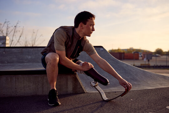 Fit man with a prosthetic blade stretching before a run