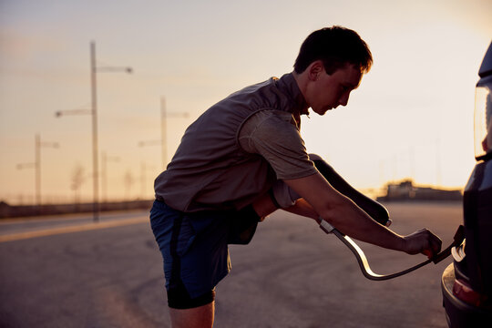 Man putting on a prosthetic running blade before a morning run