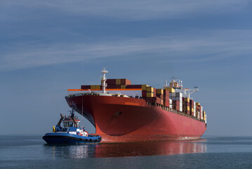 MARITIME TRANSPORT - The container ship sails to port with assistance of a tug - obrazy, fototapety, plakaty