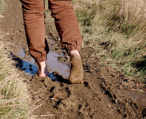 Walking in nature barefoot in the mud - 704883566