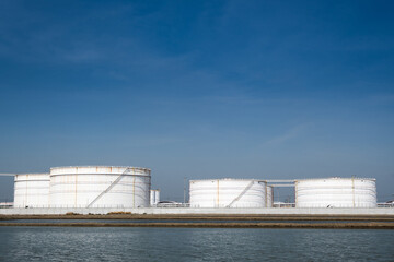 Obraz premium Large crude oil tanks are used to store crude oil, which is a type of unrefined petroleum. Crude oil is a thick, black liquid that is extracted from the ground