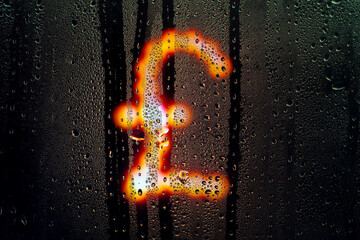 Blurred glowing English pound sign made from light bulbs.The symbol of the national currency behind a rain-wet window with water drops in the night.Sign of economic crisis and business problems - obrazy, fototapety, plakaty