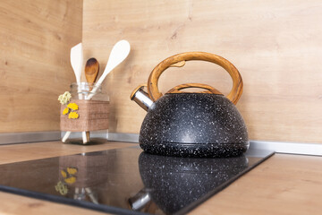 granite kettle, ceramic stove and kitchen spatulas