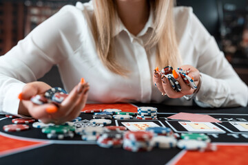 Pretty woman playing poker makes a bet with chips all in