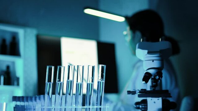 Lab assistant, a medical scientist, a chemistry researcher holds a glass tube through the blood sample, does a chemical experiment and examines a patient's blood sample. Medicine and research concept.