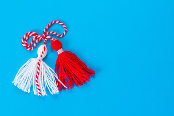 Bulgarian symbol of spring white and red martenitsa on blue background