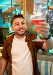 Hawaiian Young Man Smiling with Cocktail in Restaurant