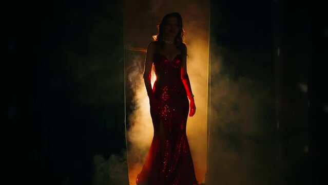 Shadow dark silhouette Retro lady sexy woman fashion model posing walking on stage black room slow motion, red long mermaid dress. beauty mystery girl old style curly wavy hair 20s new year holiday