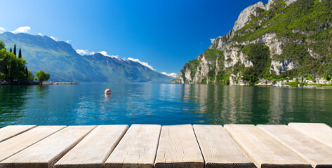 Empty wooden table and summer view of lake Garda in Italy, Europe - obrazy, fototapety, plakaty