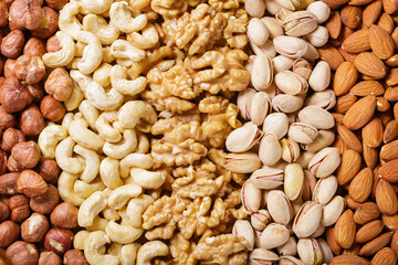 Mixed nuts as background, top view. Walnut, hazelnut, pistachio, cashew and almond nuts