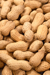 Unshelled peanuts as a background, top view. Food peanut closeup