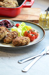 Meatballs with salad and cherry tomatoes on a plate. Selective focus.