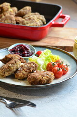 Meatballs with salad and cherry tomatoes on a plate. Selective focus.