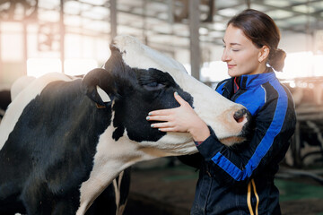 Concept agriculture cattle livestock farming industry. Happy young woman farmer hugging cow