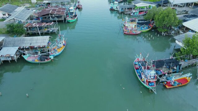 Drone flies over this estuarine river revealing this fishing village, boats and people swimming as seen from above, Bang Pu Fishing Village, Sam Roi Yot National Park, Prachuap Khiri Khan, Thailand.