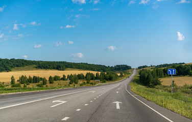Fototapeta premium A road with dramatic clouds in a blue sky.