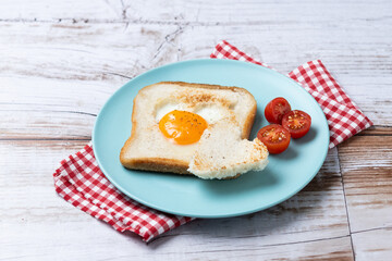 Valentine's Day breakfast with egg with tomatoes, heart shaped and toast bread on wooden table