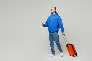 Traveler young middle eastern man wear blue casual clothes hold bag go isolated on plain solid white background. Tourist travel abroad in free spare time rest getaway. Air flight trip journey concept.