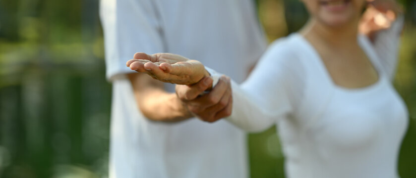 Cropped shot senior couple practicing Tai Chi in the park. Mental health and retired lifestyle concept