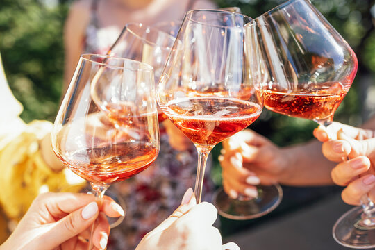 Making a celebratory toast with sparkling wine. Female hands holding glasses of champagne