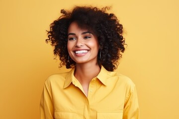 Obraz na płótnie Canvas Portrait of a beautiful african american woman smiling over yellow background