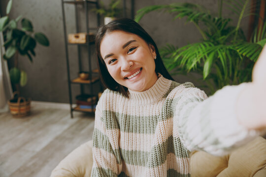Close up young woman wear casual clothes do selfie shot pov on mobile cell phone sits on armchair stay at home hotel flat rest relax spend free spare time in living room indoor. People lounge concept.