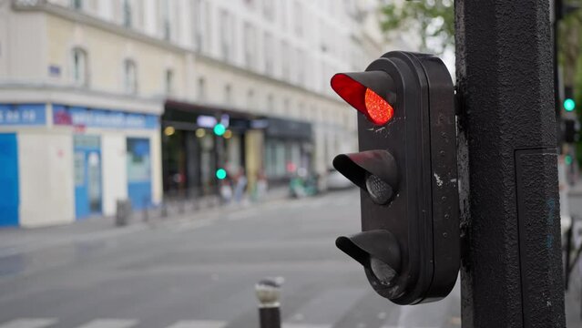 Slow motion video of a pedestrian crossing a street in Paris with a traffic light. 4k