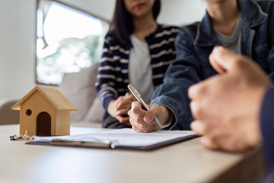 real estate agent present a contract for sale of a home to an LGEBTQ cilent. Real estate contract signing concept