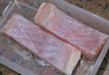 Raw fish cuts out of refrigerator, ready to cook.