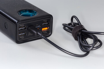 Front panel of power bank with ports and connected cable