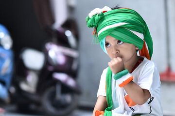 Indian baby girl wearing Indian national flag printed white t-shirt, tricolor turban and bands in...