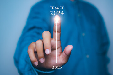 Young man pointing target in 2024. Progress growing potential success new business.