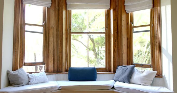 Big living room with couch and pills at big wooden windows