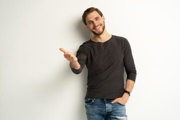 Positive young man pointing aside with fingers hand gesture at copy space advertising product, presenting sale discount standing isolated on white - obrazy, fototapety, plakaty