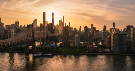 Obraz premium Evening New York City Landscape Over East River with Upper East Side Skyscrapers and Ed Koch Queensboro Bridge. Cinematic Urban Skyline with Sunset and Lightly Clouded Sky