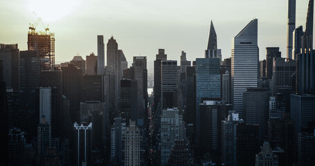 Fototapeta na wymiar Moody Cinematic Aerial Sunset Image of New York City Skyscrapers and Busy City Streets with Car Traffic. Panoramic Helicopter View of Lower Manhattan Office Buildings