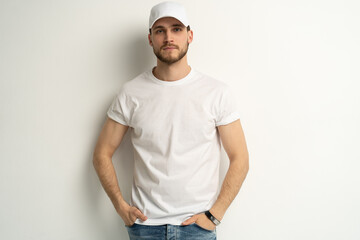 Handsome man wearing blank white cap and white t-shirt isolated on white background.