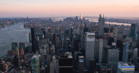 Fototapeta premium Helicopter Tourist Tour Around New York City. Aerial View with a Picturesque Sunset Landscape View Over Manhattan Skyscrapers, with Hudson River and Jersey City