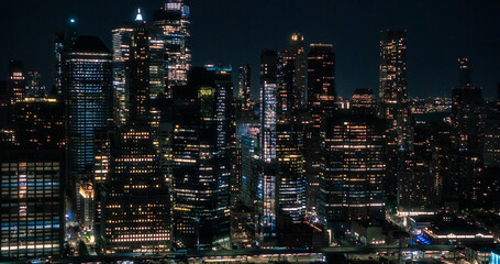 Wall Street Office Buildings Lit Up at Night: Scenic Aerial New York City View of Lower Manhattan Architecture. Panoramic Financial District Shot from a Helicopter. Evening Cityscape of NYC