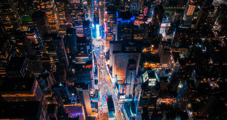 Night Aerial Photo of New York City with Skyscraper Spires and Straight Busy Streets with Cars and...