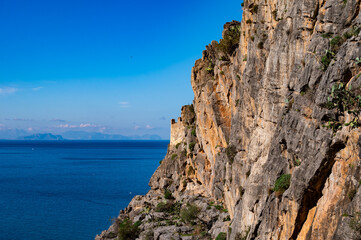 Rough texture of a rock with the blue sea and sky in the background, Cefalu, Italy