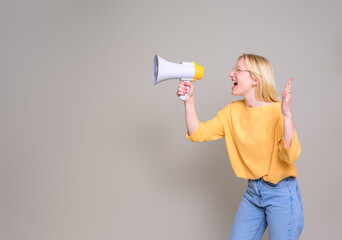 Female young businesswoman screaming over megaphone and making announcement on white background
