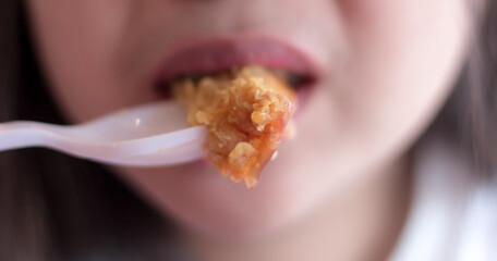 Woman eating fried chicken blurred background, Street food