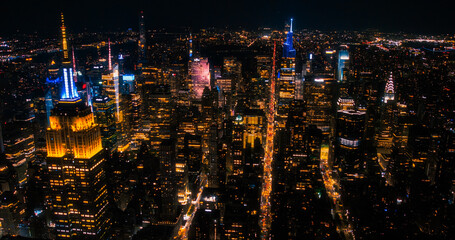 Fototapeta na wymiar New York City Aerial Night Cityscape with Stunning Manhattan Landmarks, Skyscrapers and Residential Buildings. Wide Angle Panoramic Helicopter View of a Popular Travel Destination