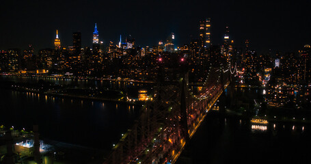 Fototapeta na wymiar Aerial Helicopter Photo Over Ed Koch Queensboro Bridge with Manhattan Skyscrapers Cityscape. Beautiful Late Evening Shot Focusing on Upper East Side Office Buildings at Night