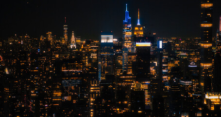 Aerial View of Midtown Manhattan Architecture at Night. Evening Shot of Financial Business District from a Helicopter. Scenery of Historic Office Towers, Including Illuminated Empire State Building